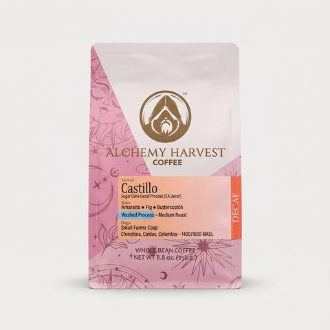 A stand-up pouch of Alchemy Harvest Coffee, Castillo Decaf, shown against a light gray background. The packaging features a pink and white design with botanical line drawings and a gold logo.