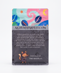 A stand-up pouch of Alchemy Harvest coffee on a clean white background. The packaging features a colorful abstract illustration at the top with blue, pink, and yellow shapes, a gray band with the website 'ALCHEMYHARVEST.