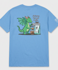 A light blue short-sleeve t-shirt with a cartoon graphic of a green dragon brewing coffee next to a coffee bag. The graphic includes the text 'Alchemy Harvest Coffee' and 'ALCHEMY HARVEST COFFEE'