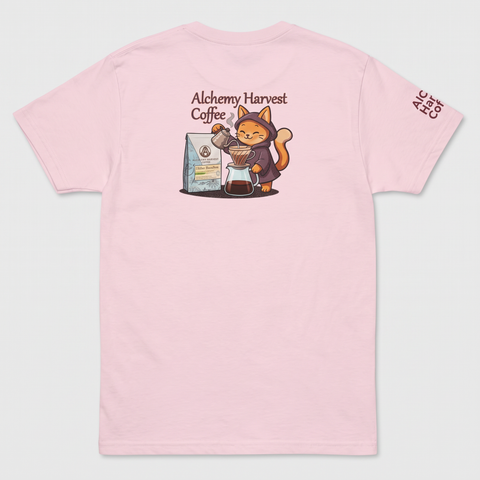 A light pink short-sleeve t-shirt shown flat against a light gray background. The back of the shirt features a cartoon graphic of an orange cat dressed as an alchemist pouring coffee, with the text 'Alchemy Harvest Coffee' above it.