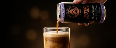 Hand pouring a can of nitro cold brew into a glass with a dark background