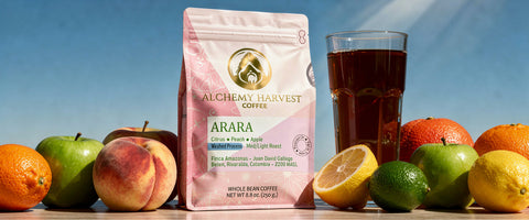 Alchemy Harvest Coffee Arara package with a glass of coffee and fruits on a wooden surface