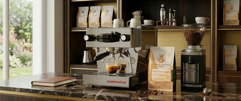 Espresso machine and coffee grinder on a kitchen counter with coffee bags and a notebook.